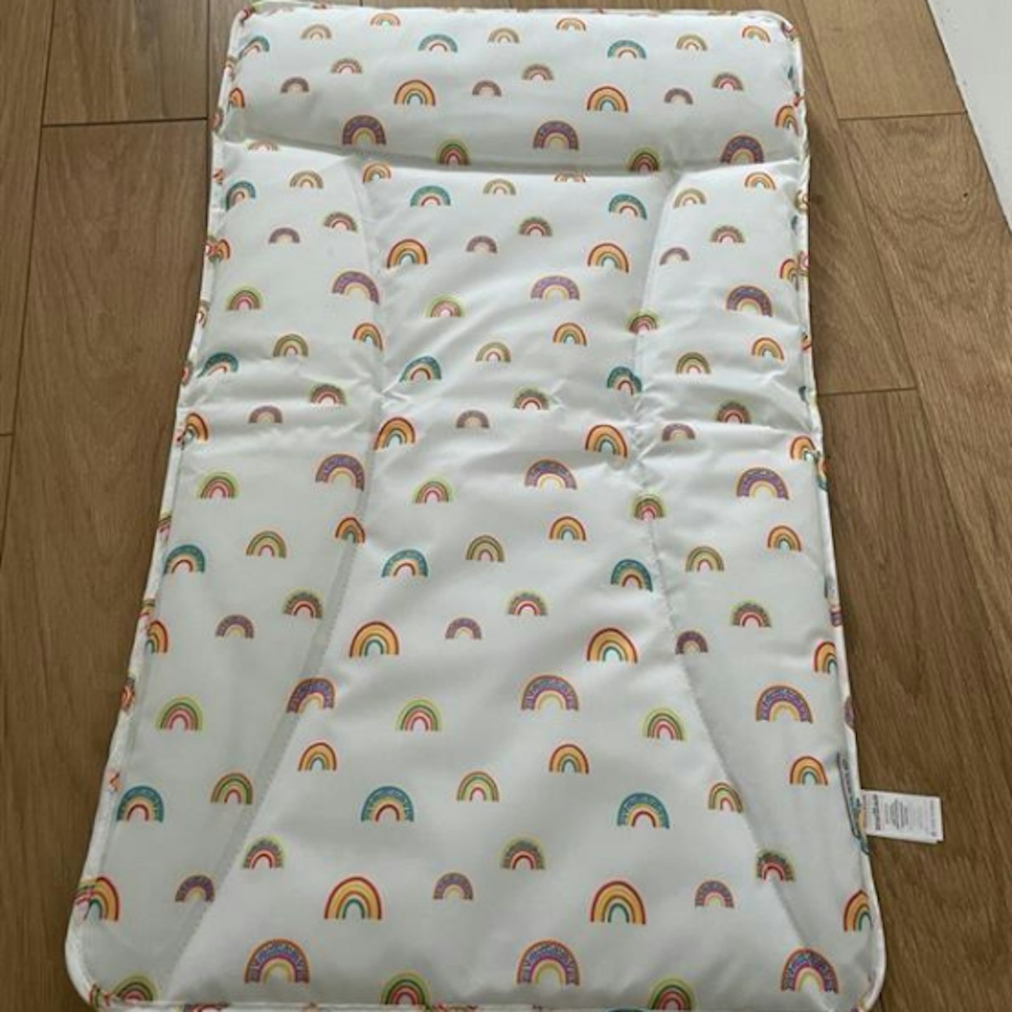 Ickle Bubba Changing mat with rainbow design laying on floor