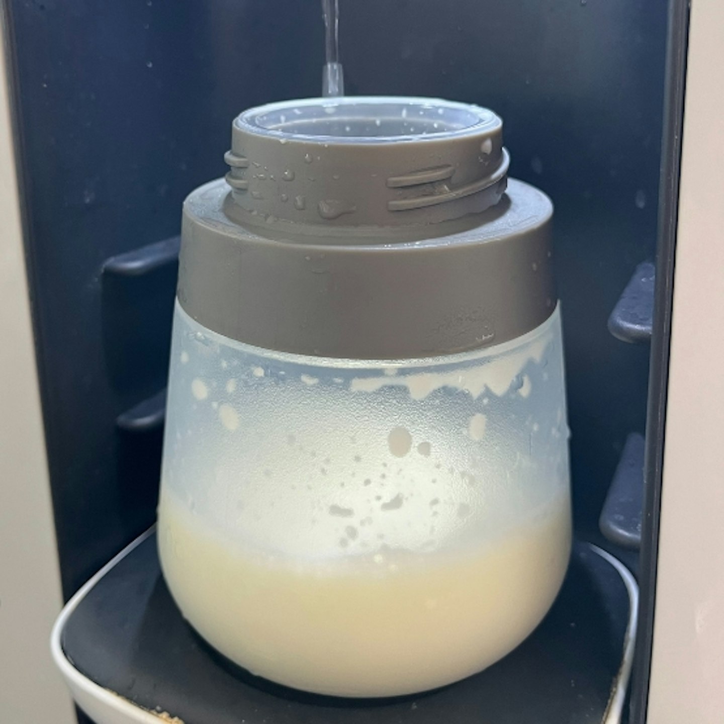 the Nanobebe Flexy Silicone Baby Bottles being filled up with milk from a machine