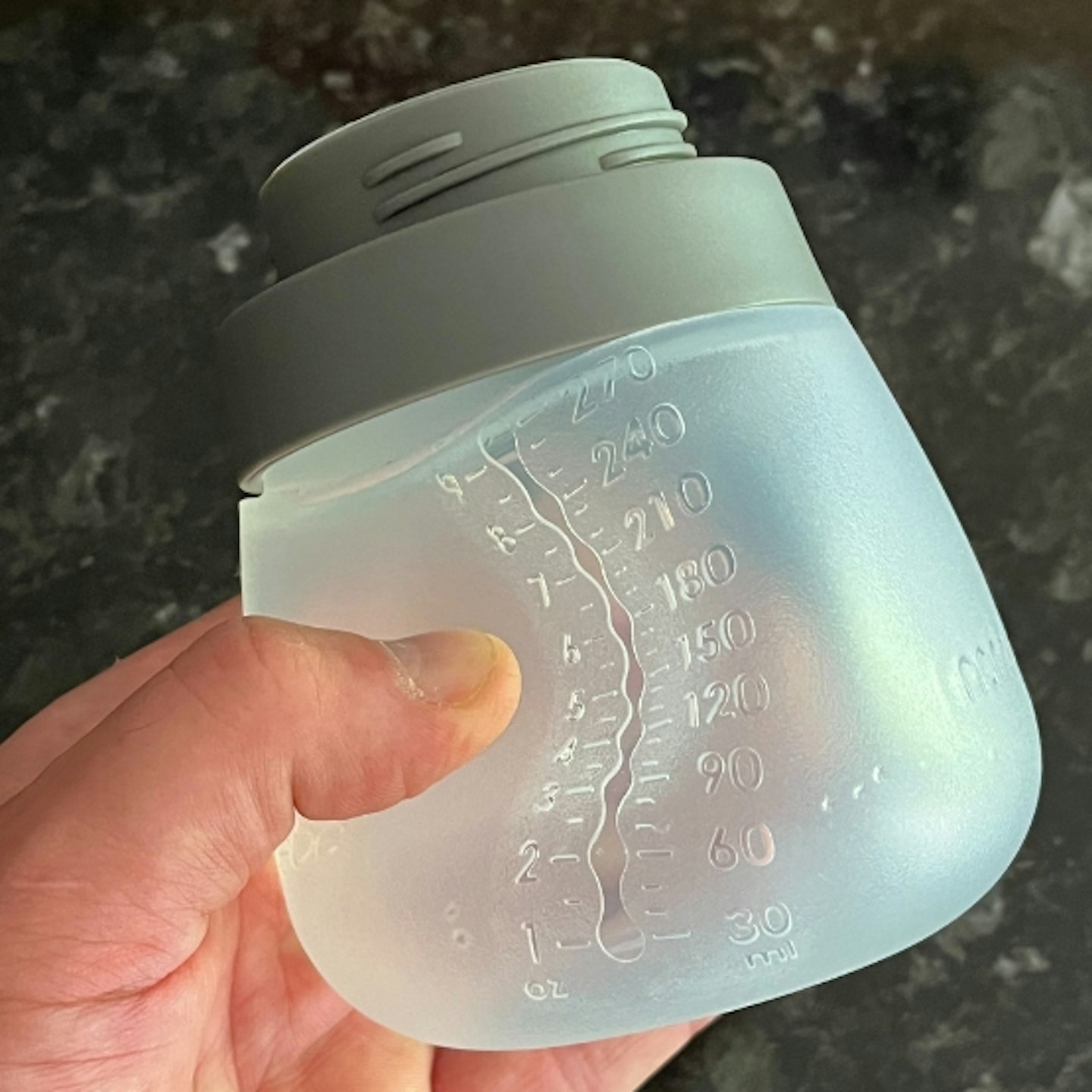 a hand squeezing a Nanobebe Flexy Silicone Baby Bottle