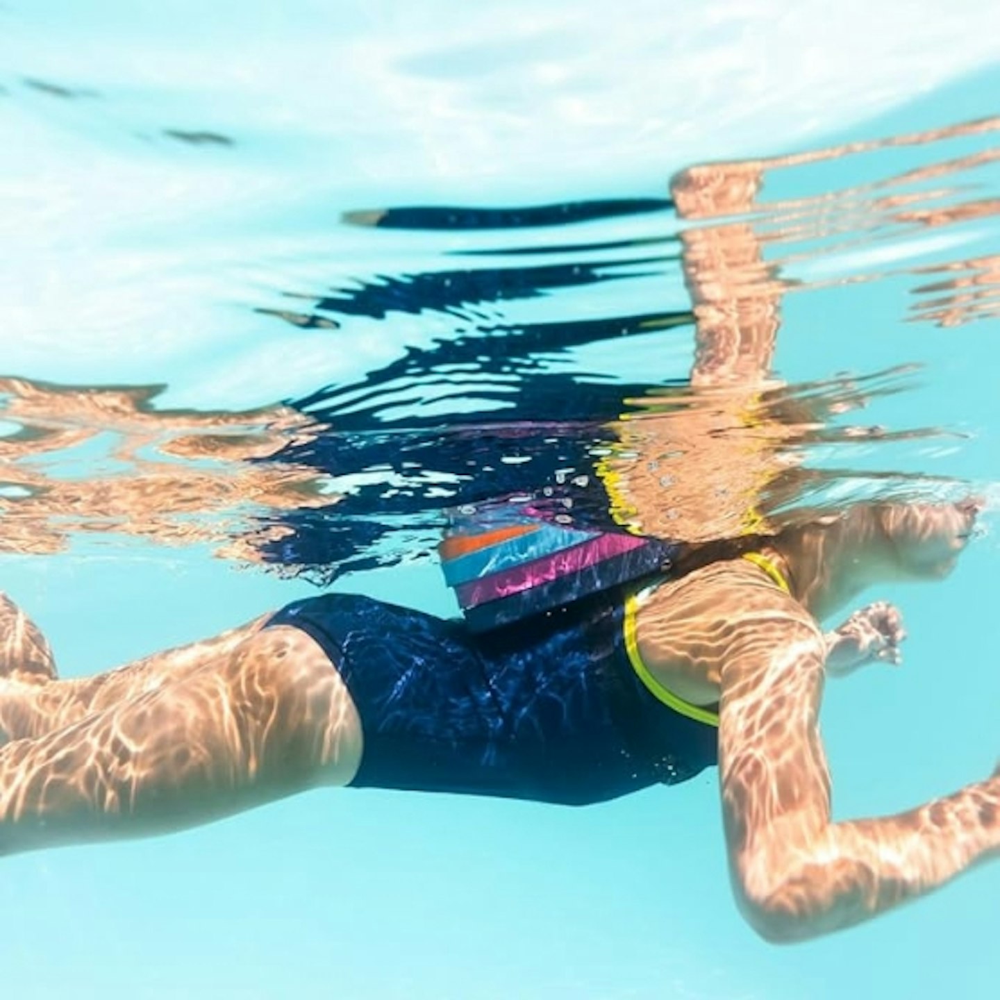 young girl wearing the Splash About Back Float in the water