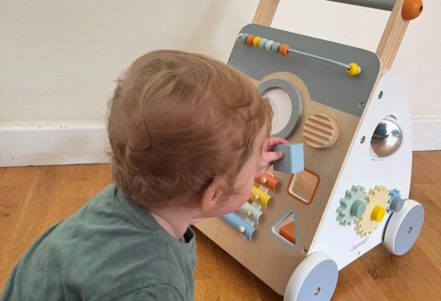 Toddler putting a square block into the Sweet Cocoon Wooden Multi-Activity Baby Walker