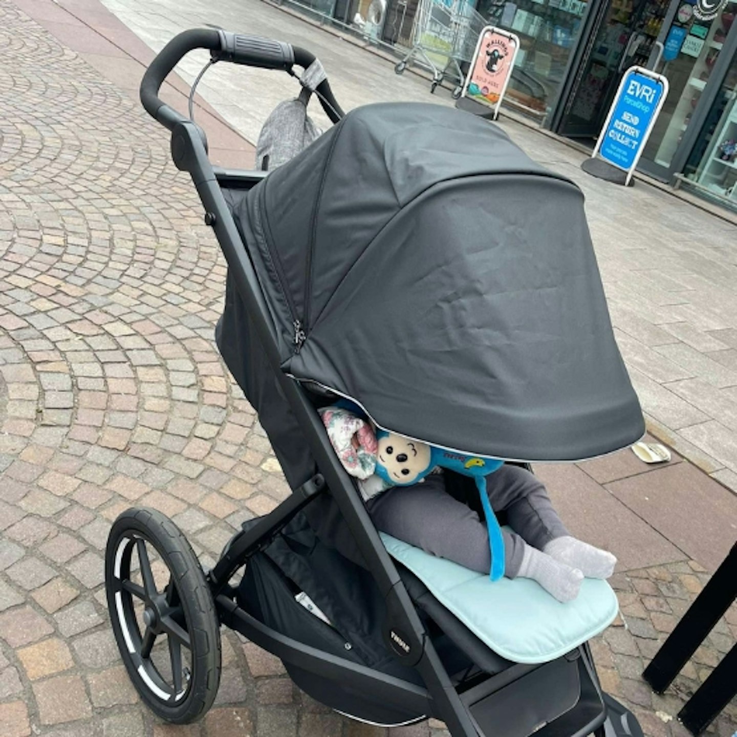 young child in the Thule urban glide 3 with the cover over