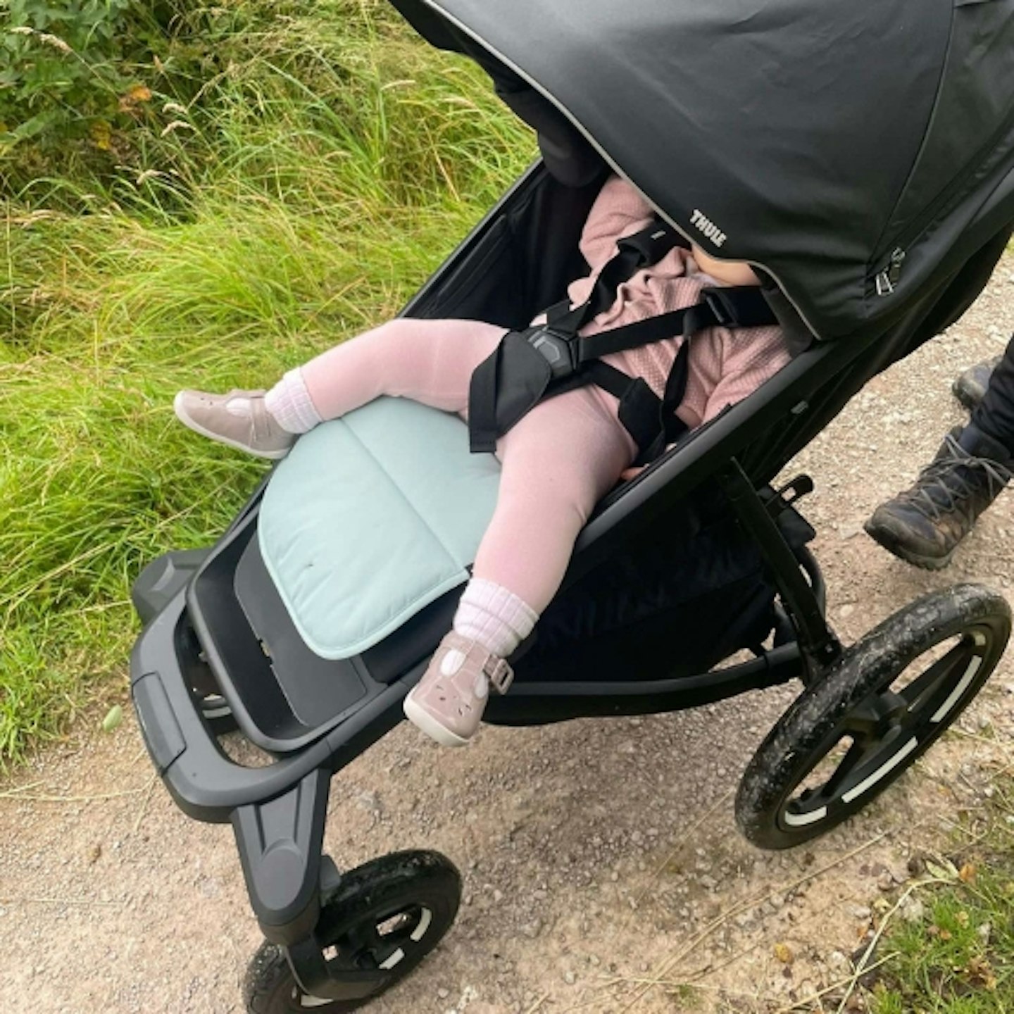 young child in the Thule urban glide 3 with the cover over