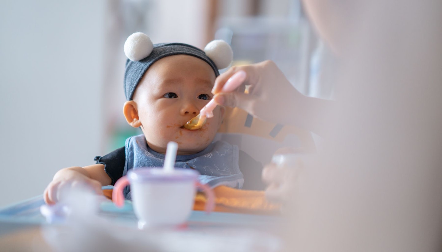 Spoon fed asian baby