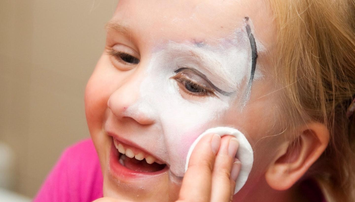 Child smiling while having face paint wiped off