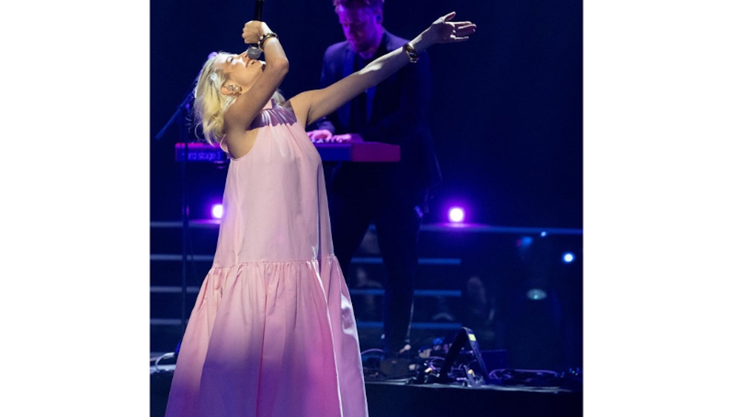 Pixie Lott performing on stage wearing a pink dress