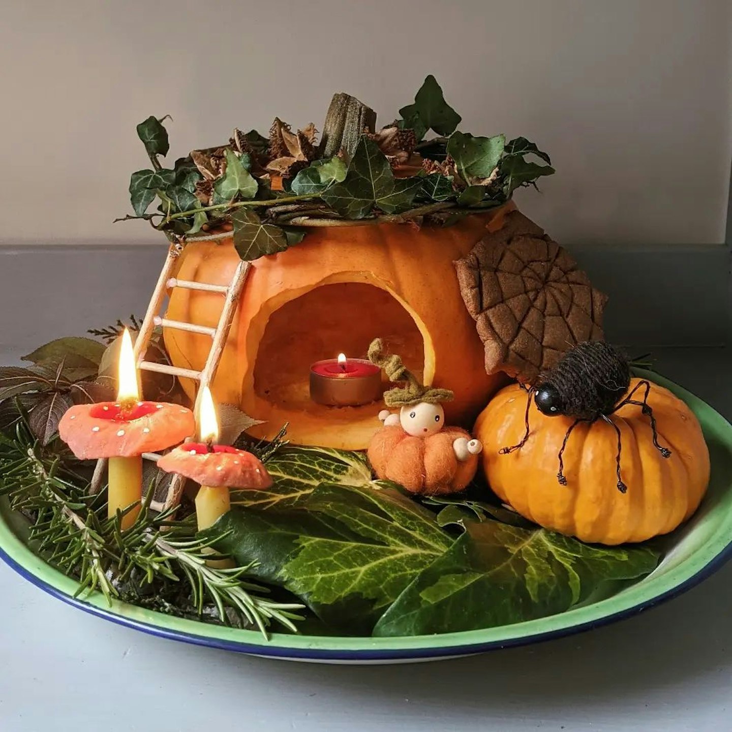 Carved pumpkin on a plate with tealights
