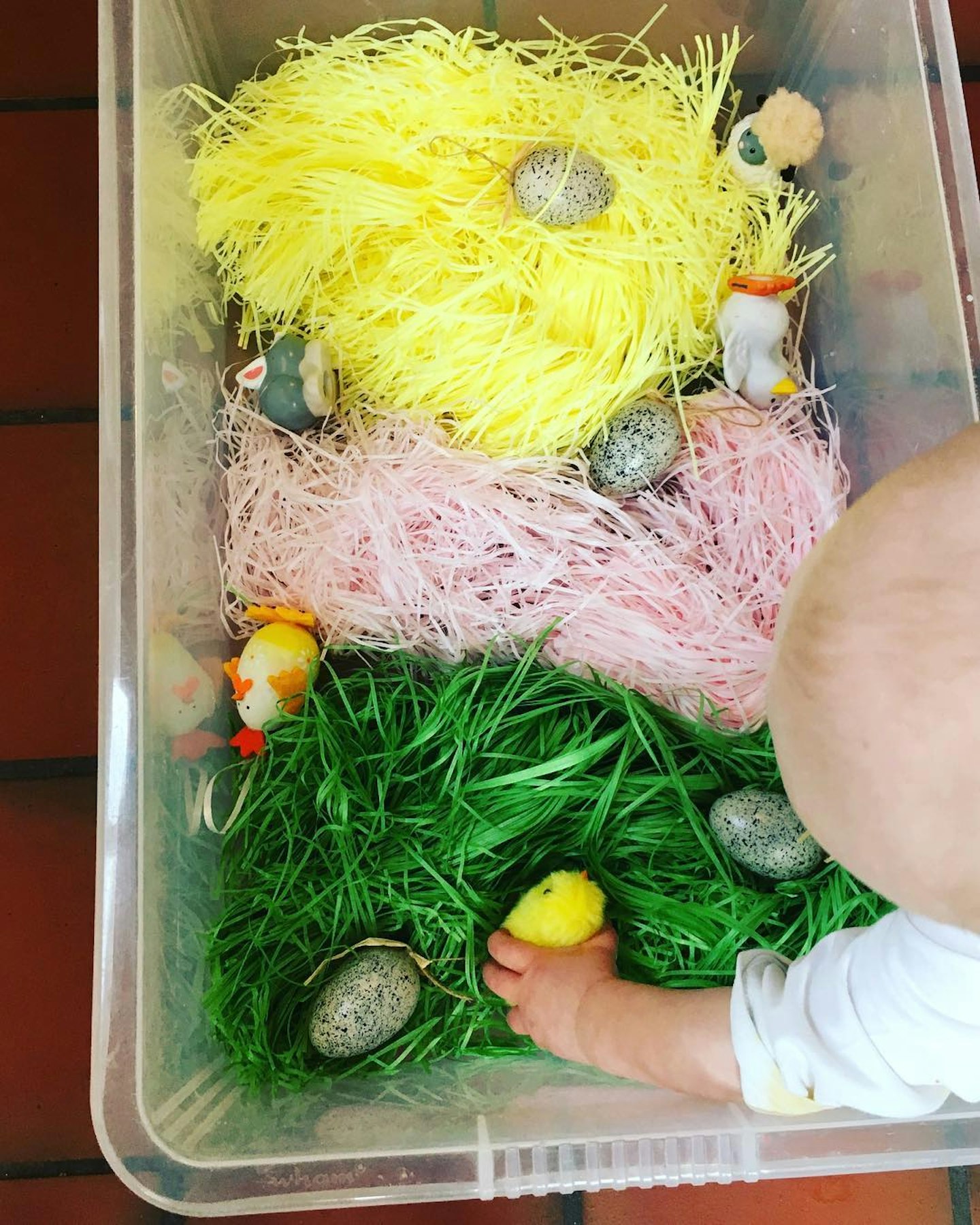 Baby playing in a shredded paper sensory bin