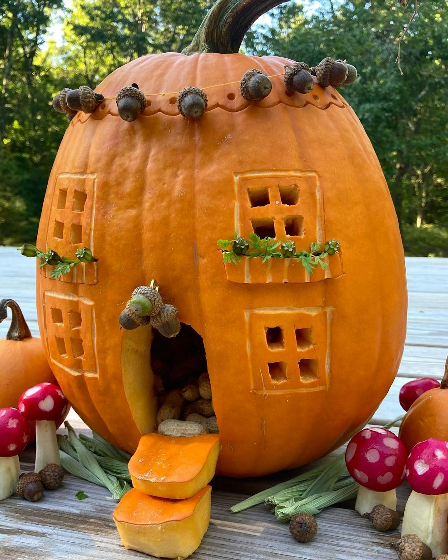 pumpkin carved into a fairies' cottage with windows and a door
