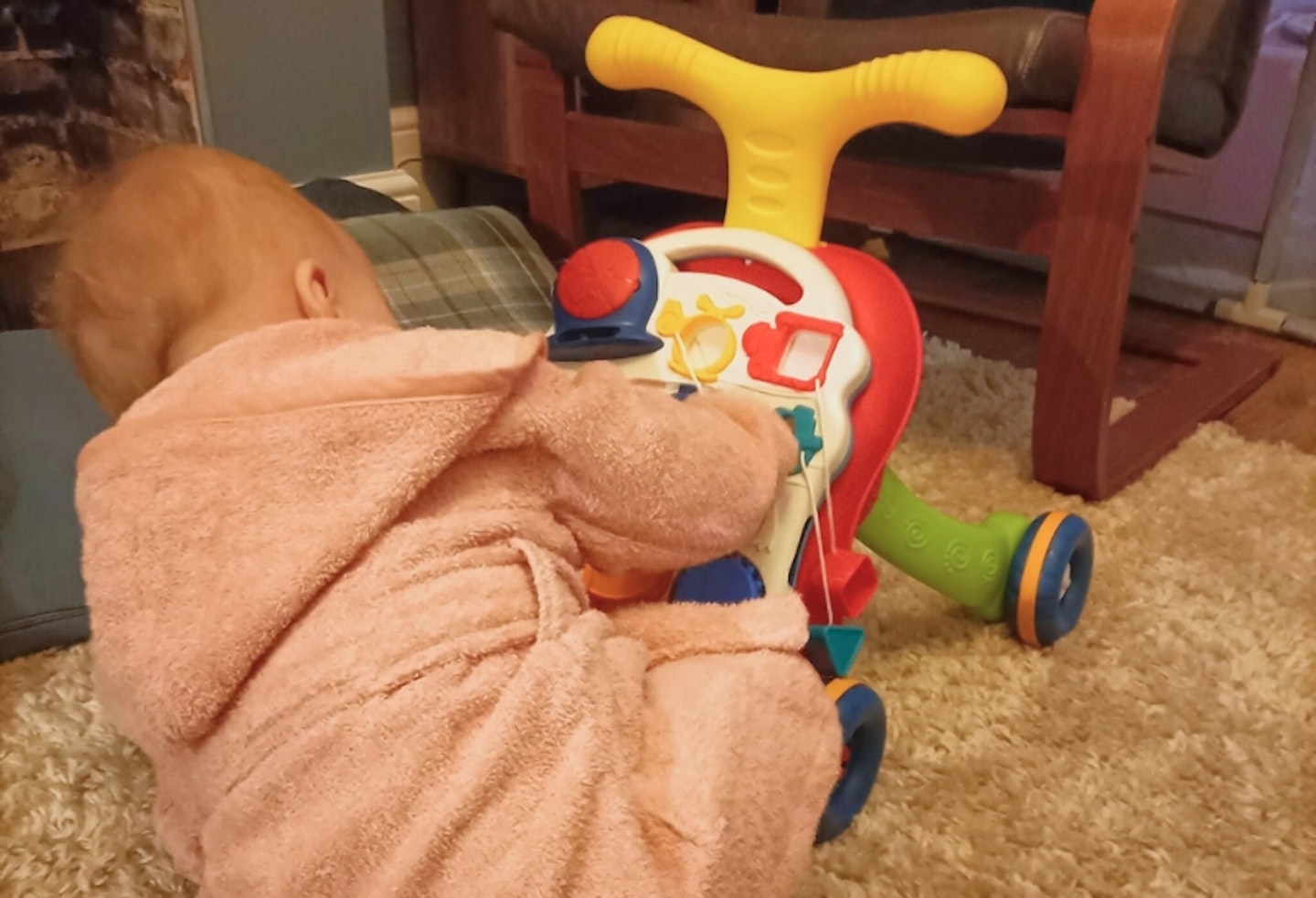 young child playing with the Stone Sit-to-Stand Learning Walker