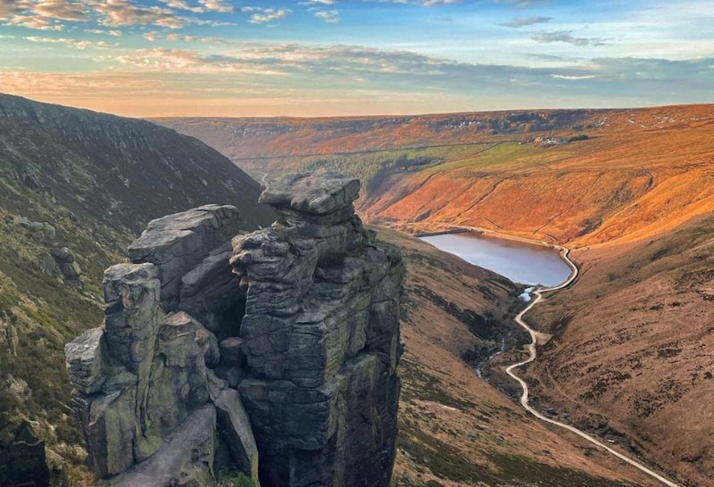 A beautiful valley with the sun shining on one side and a river through the middle