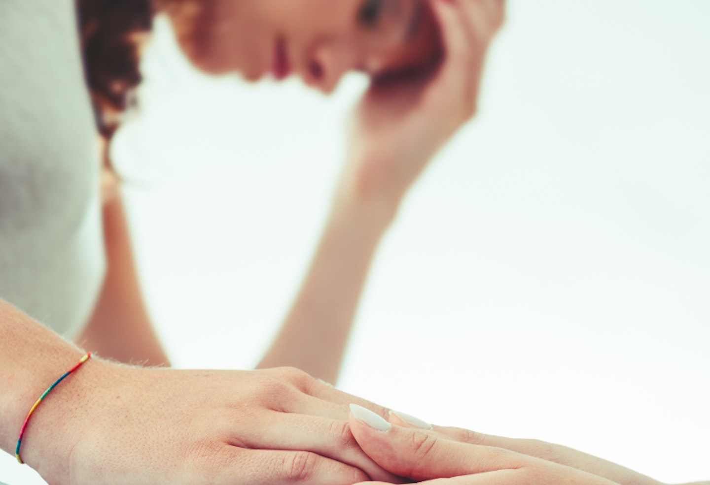 Friends comforting by holding hands