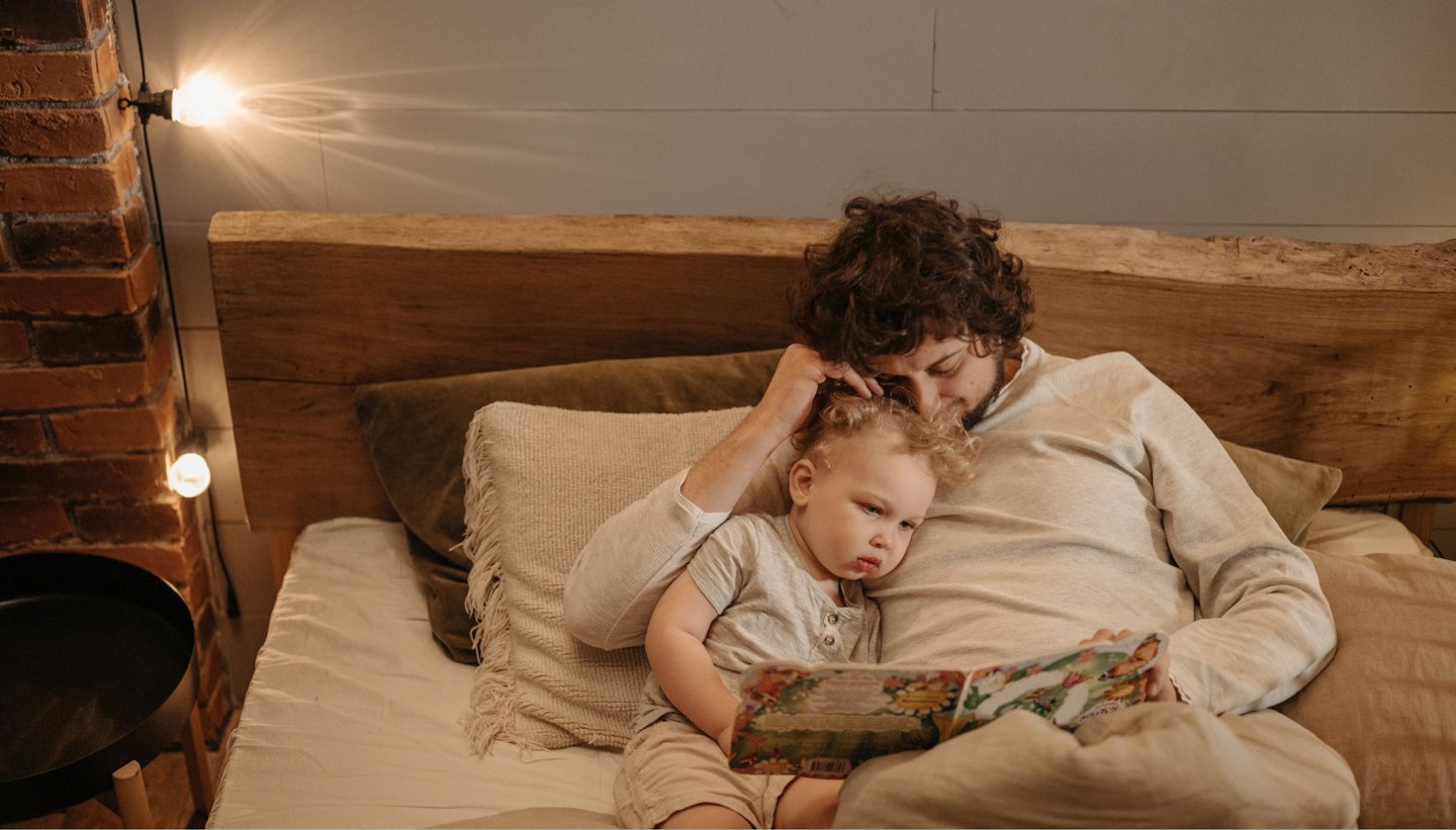 Dad Reading Bedtime Story to His Child