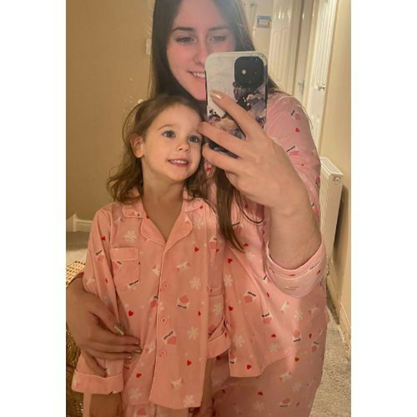 A mum and daughter wearing matching Christmas pyjamas 