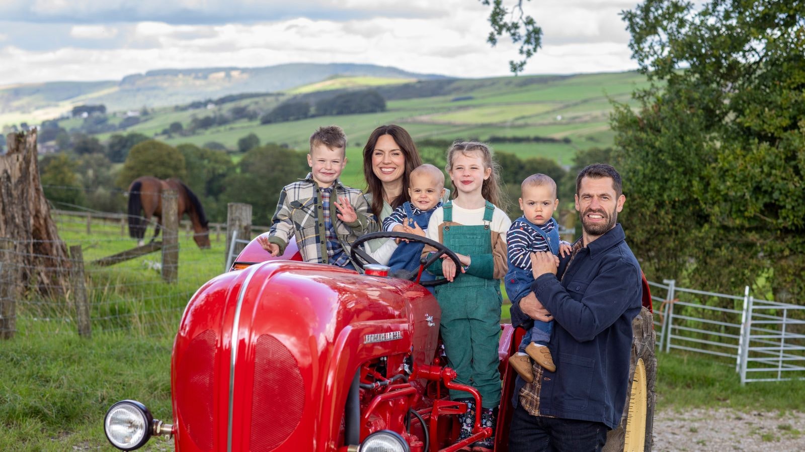 Liz and Kelvin Fletcher and their children Marnie, seven, Milo, aged four, and 18-month-old twins, Mateusz and Maximus on a red tractor.