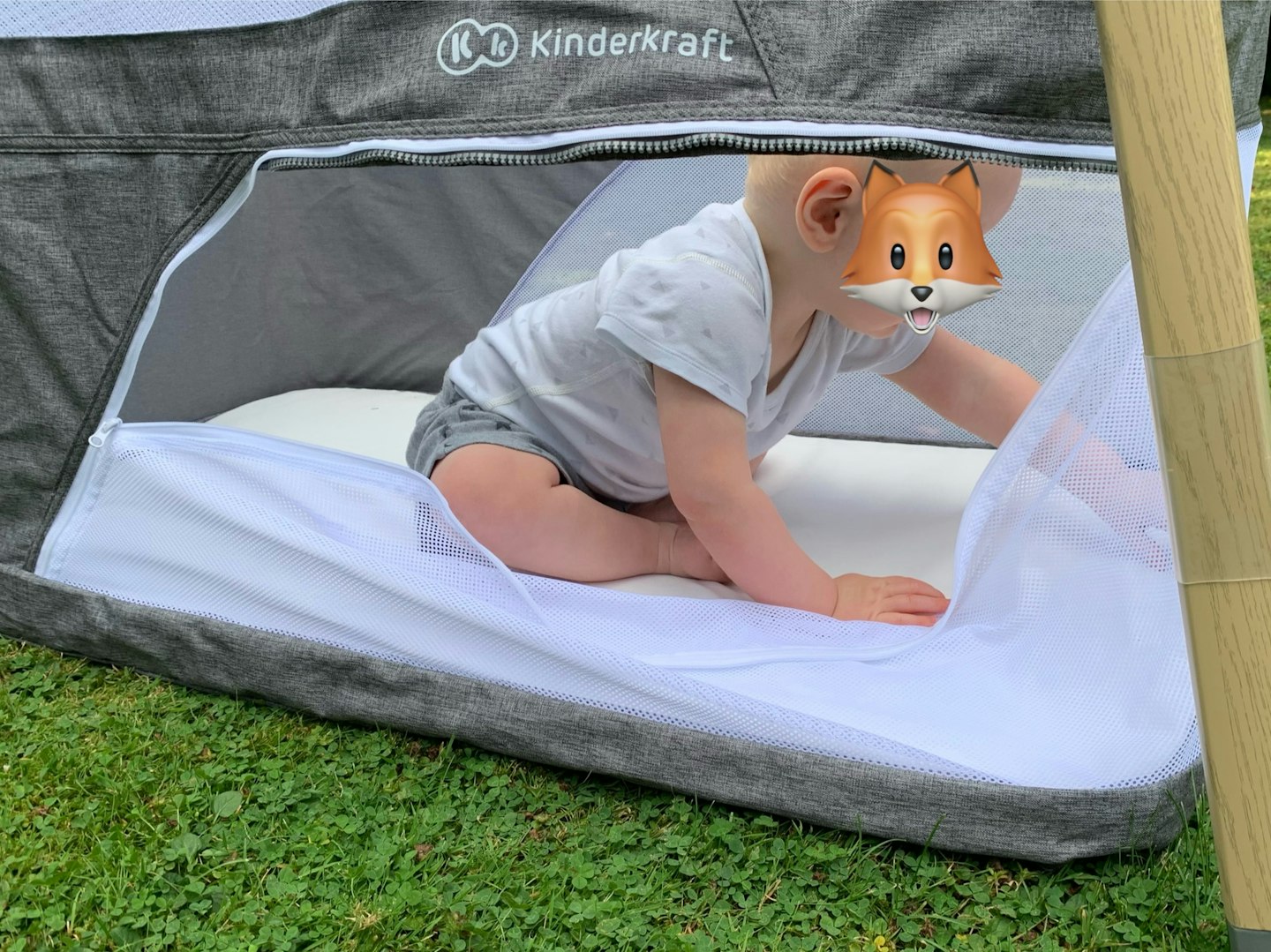 Kinderkraft cot and playpen with a baby playing inside