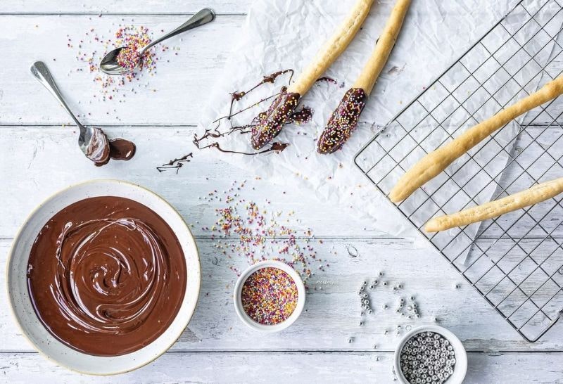 A photo of churros and chocolate with sprinkles