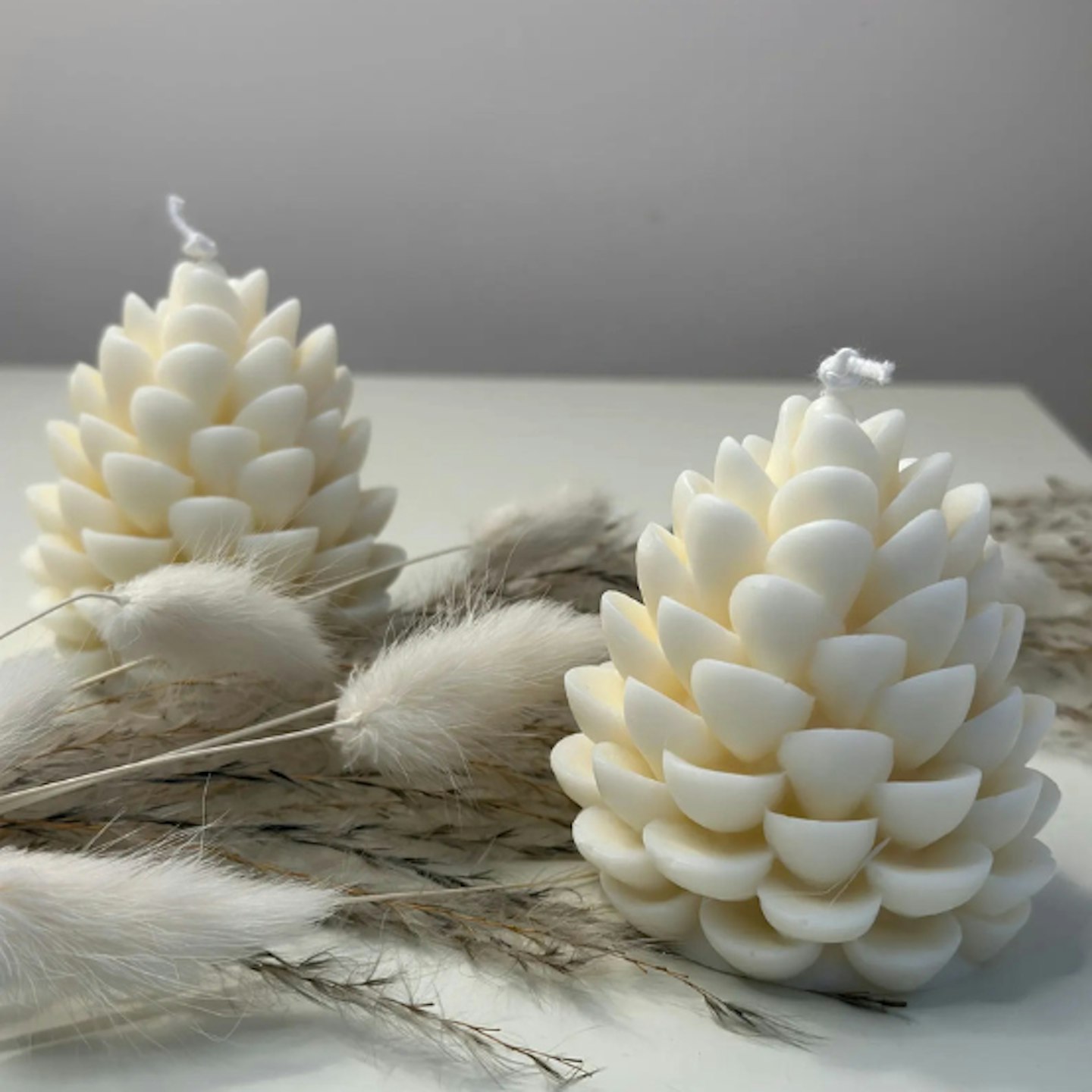 A pair of white pinecone shaped candles