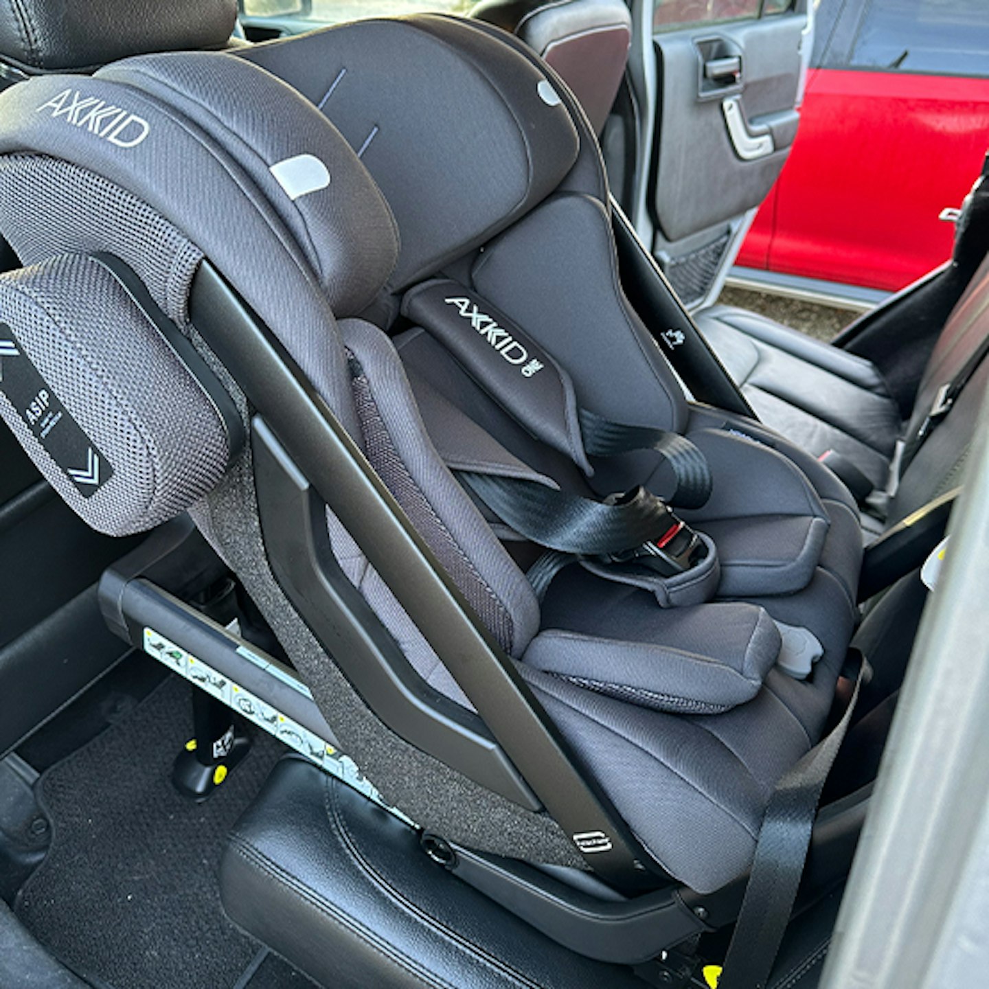 View of the Axkid One 3 car seat fixed in the back seat of the car