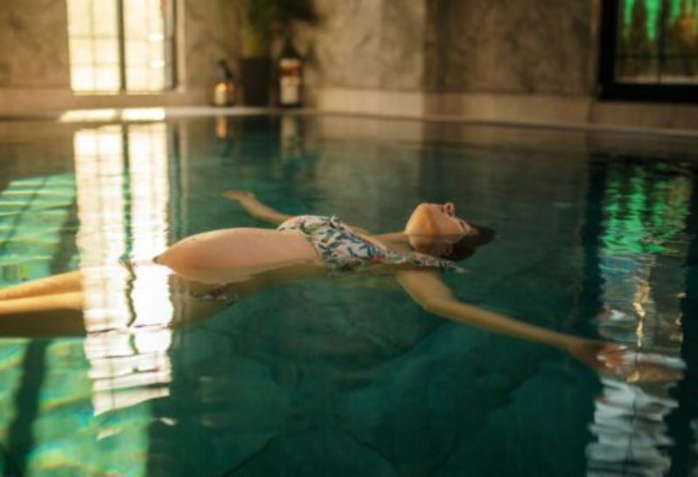 A pregnant woman floating on her back in a spa pool