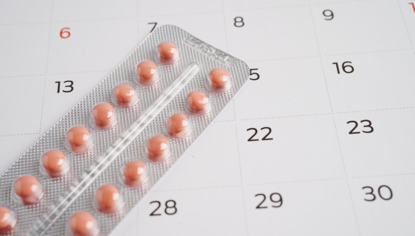 A pack of birth control tablets on top of a calendar