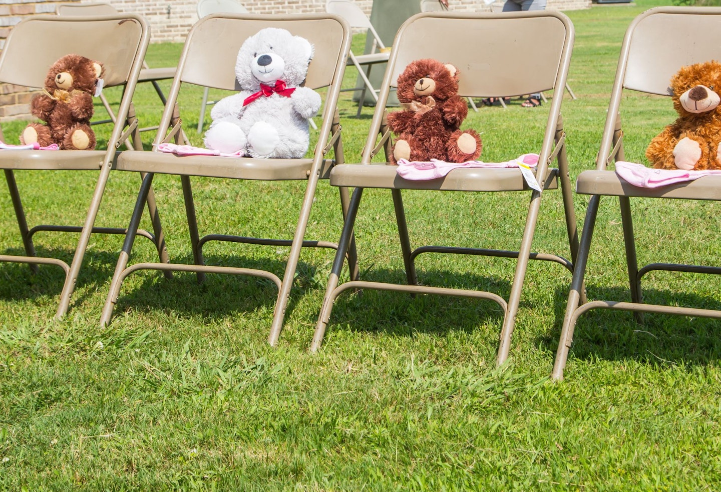 Four teddy bears lined up for a baby shower game outdoor