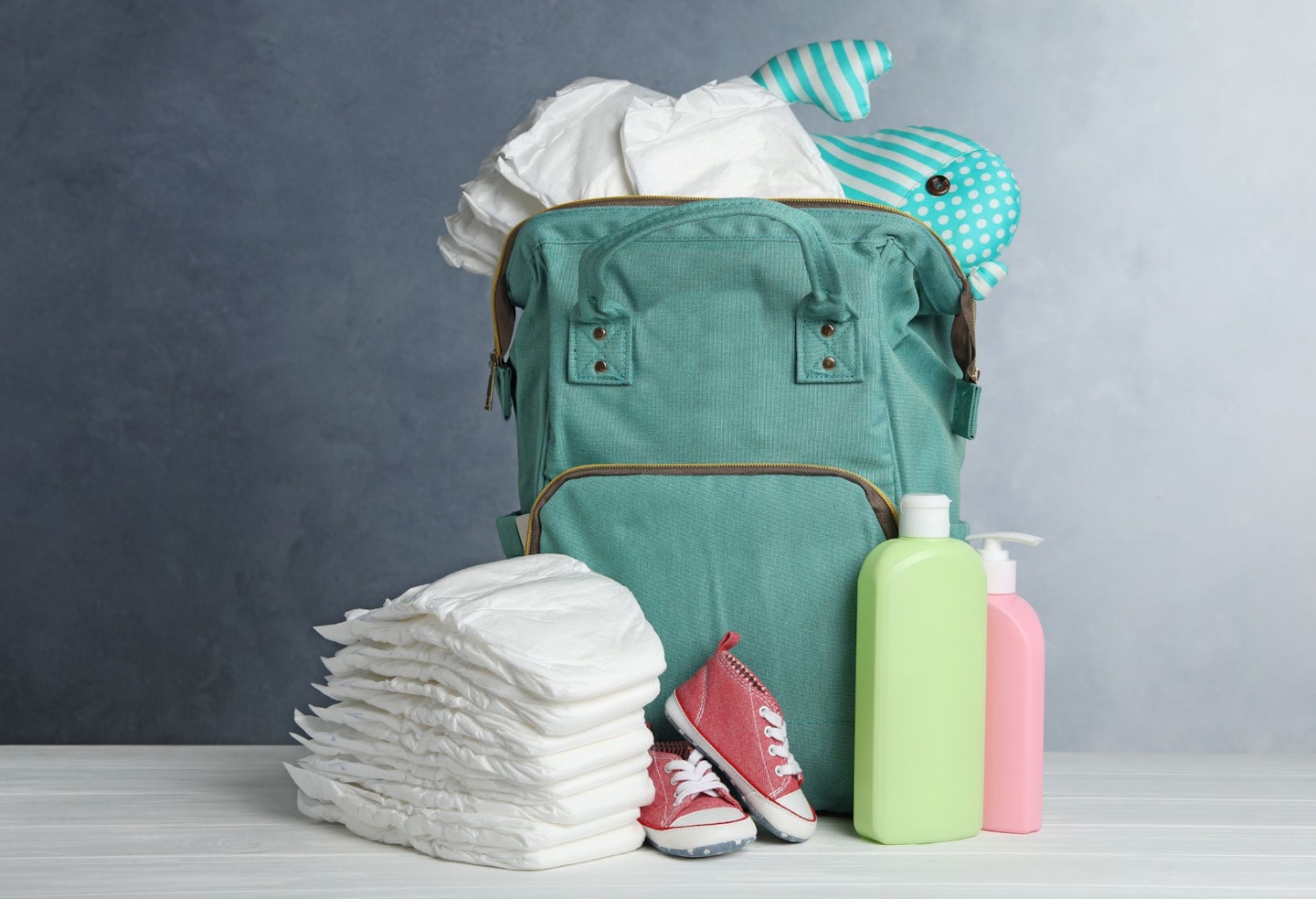 Bag with Diapers and Baby Accessories on White Wooden Table Agai