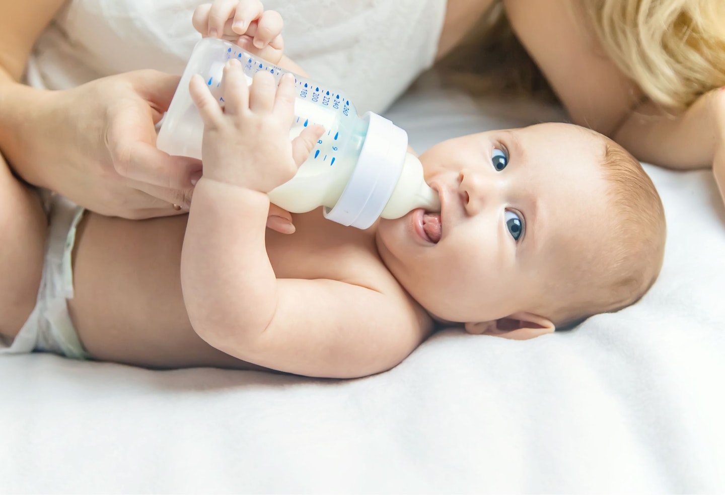 Mother Feeding Milk To Baby Through Bottle At Home