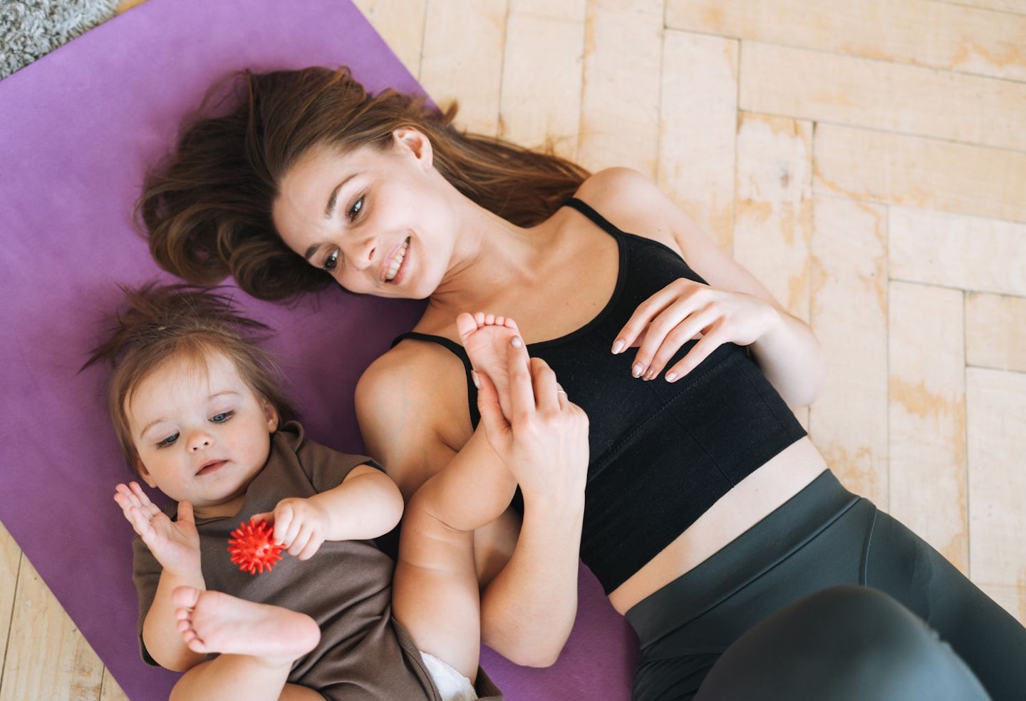 Mum with baby girl doing exercises with massage