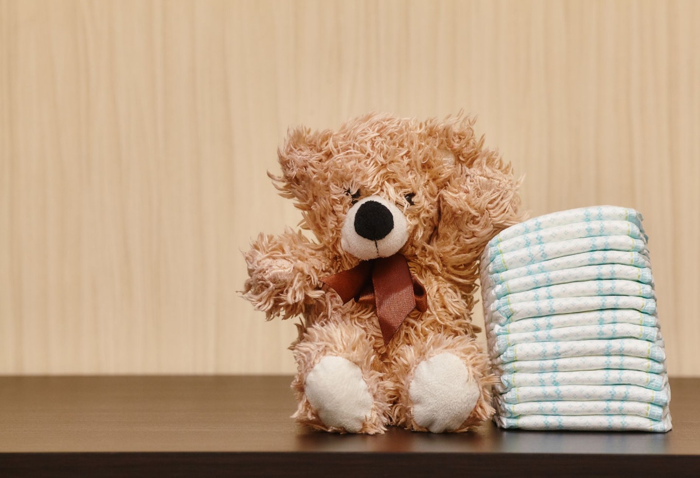 Stack of diapers or nappies with teddy bear