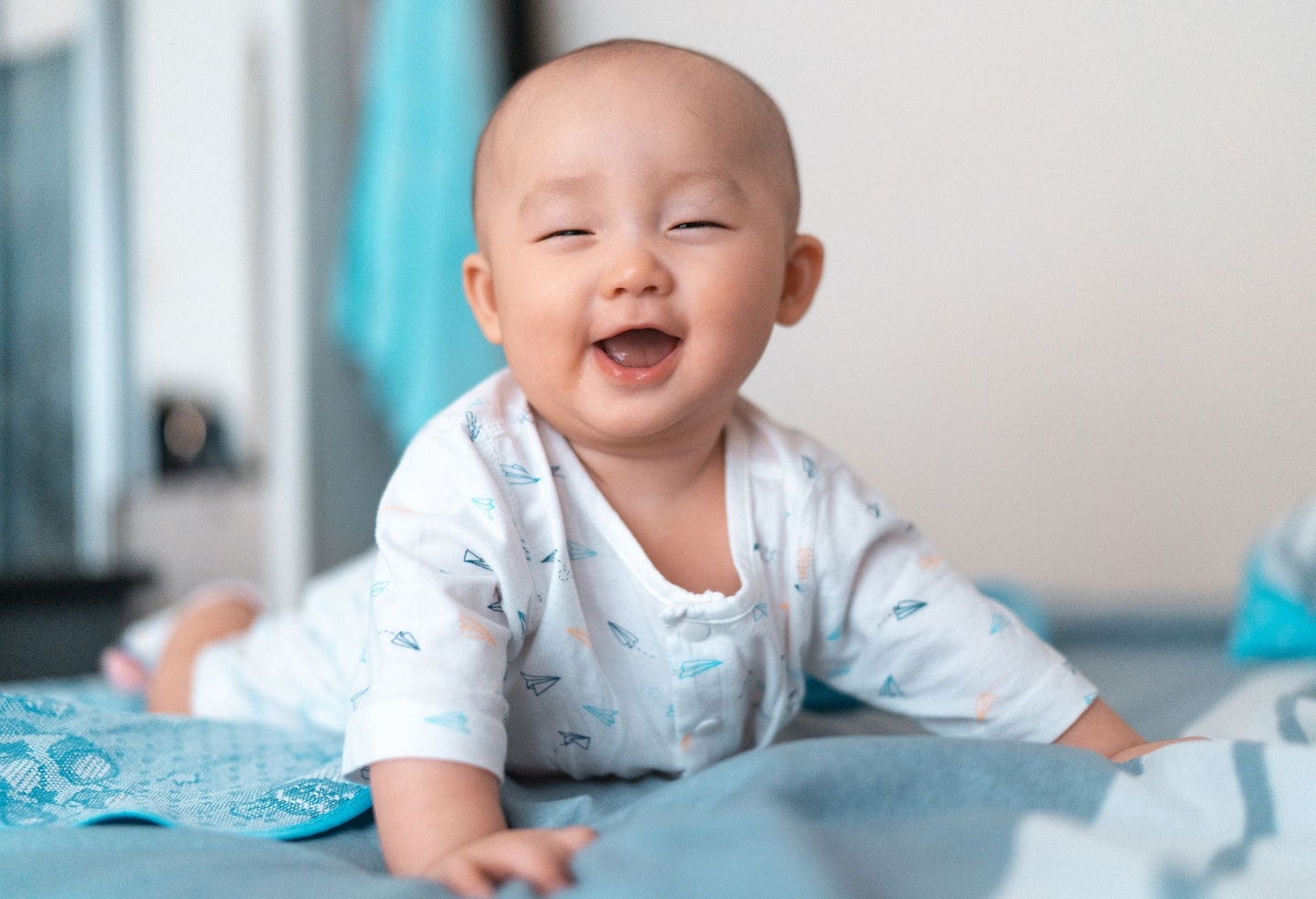 asian baby laughing happily when doing tummy time