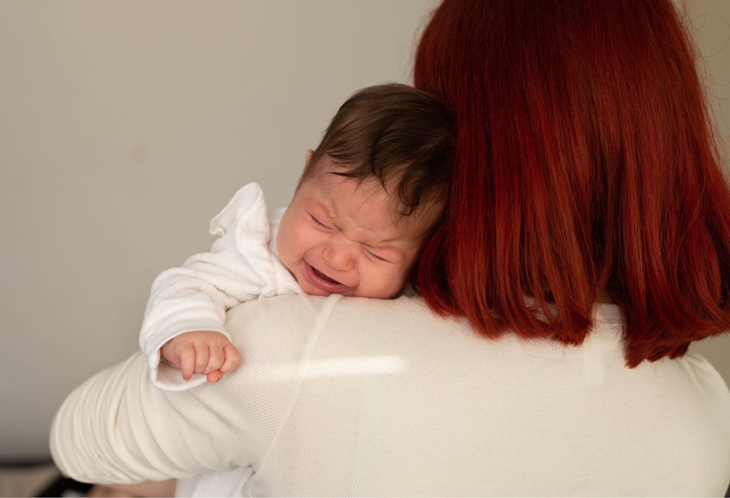 Baby crying on mom's shoulder