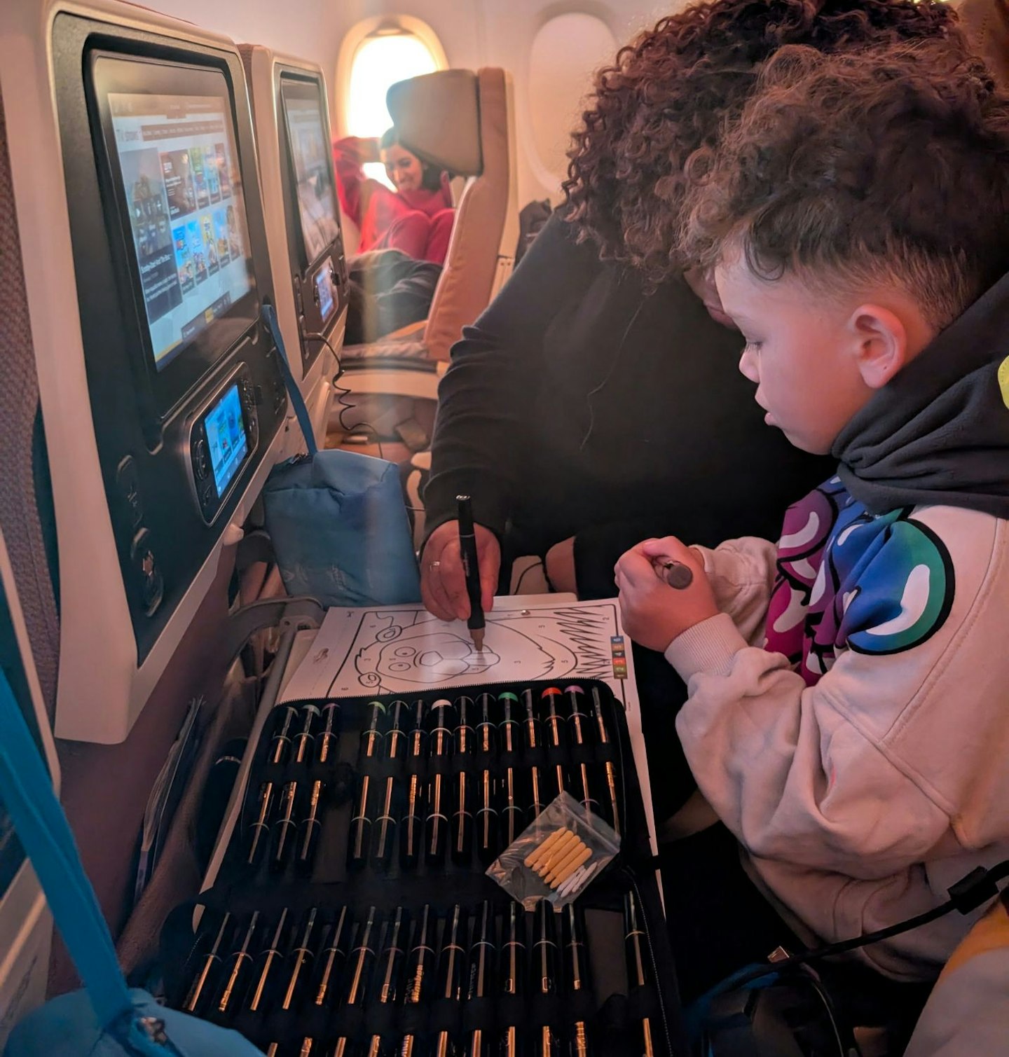 Young boy and grandmother testing Ohuhu Acrylic Paint Pens 30 Colours when travelling on an airplane. 