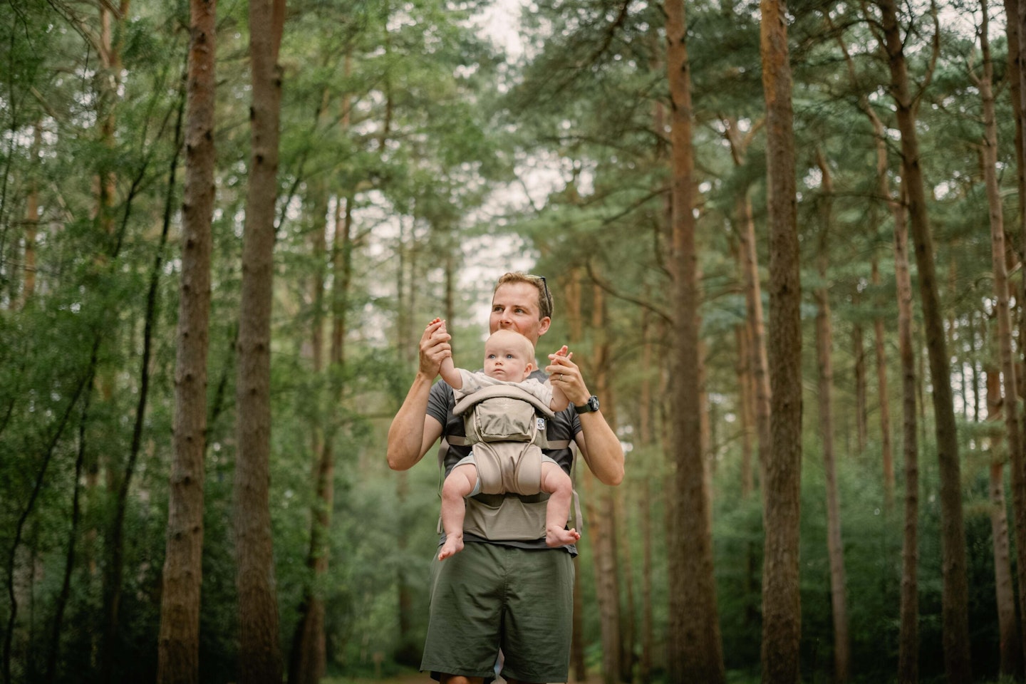 man in woods with baby in osprey carrier