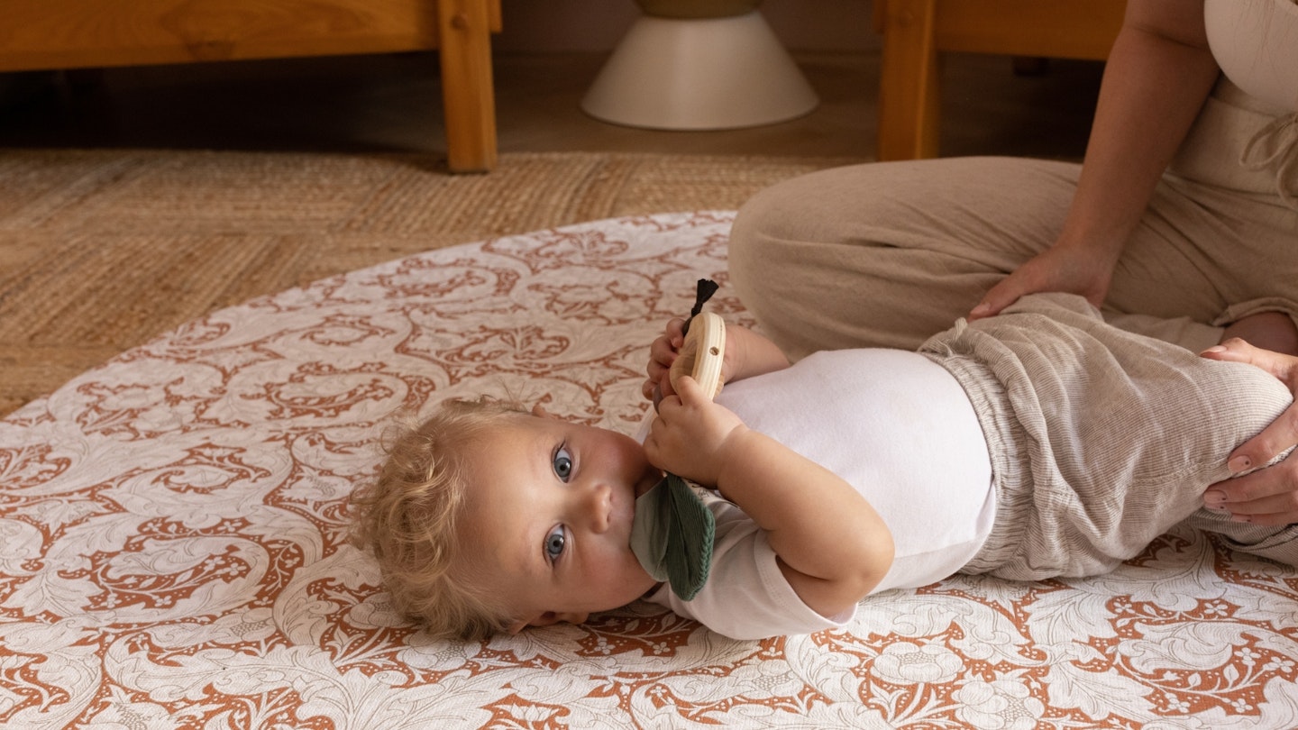 Totter+Tumble Lifestyle image of a baby laying on a playmat.