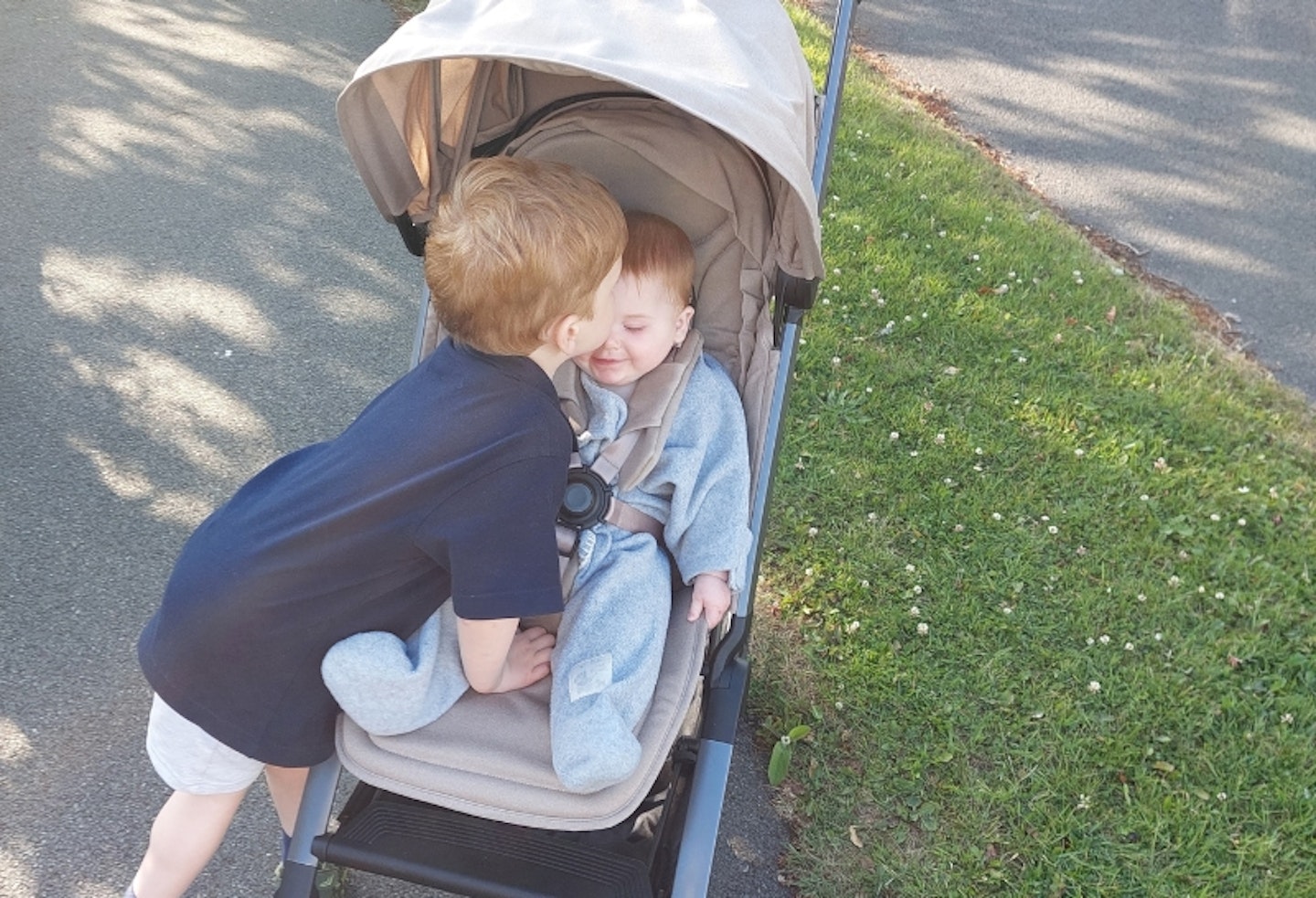 little boy giving the young baby in the Joolz Aer2 a kiss on the forehead