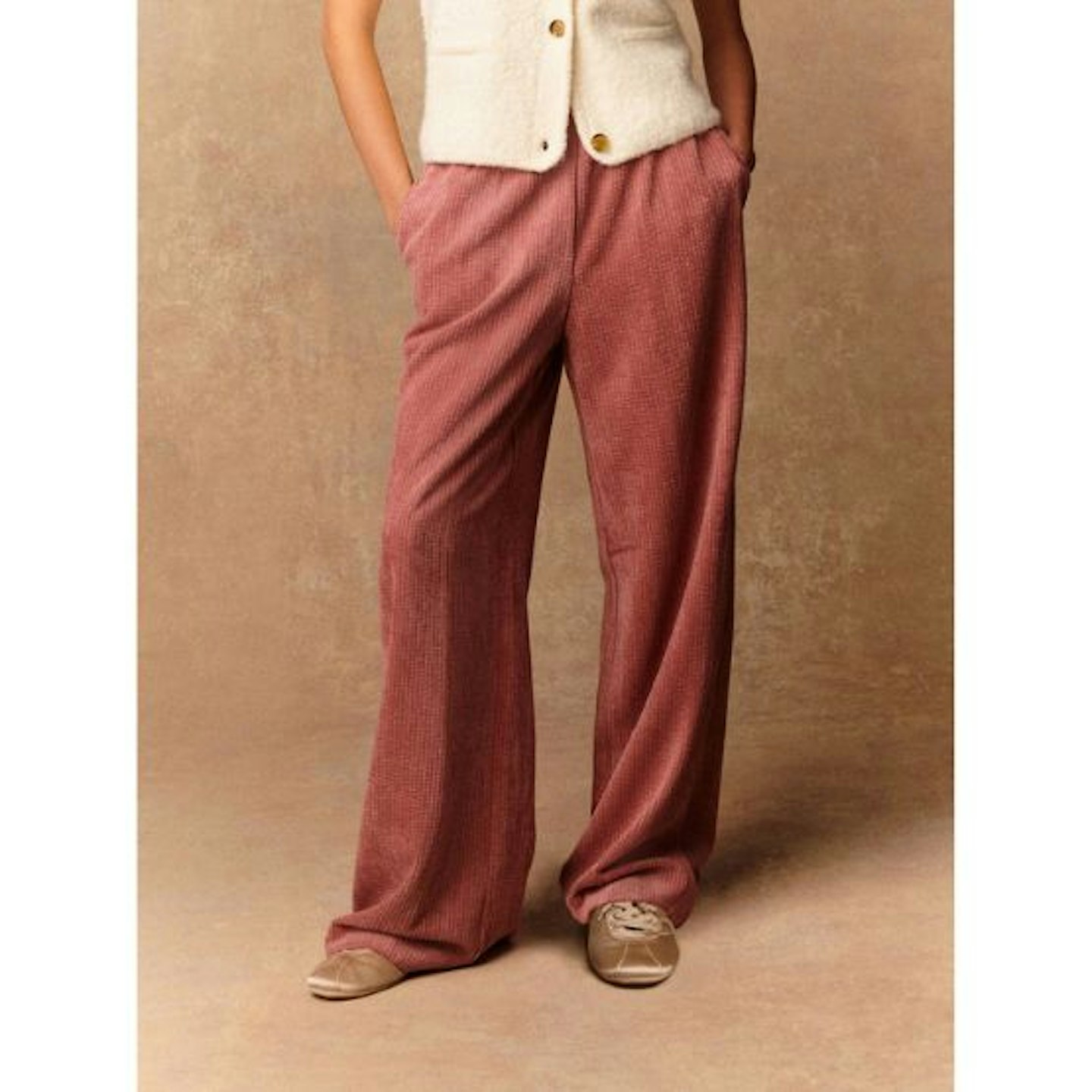 Woman wearing pink cord trousers from Next with a white top