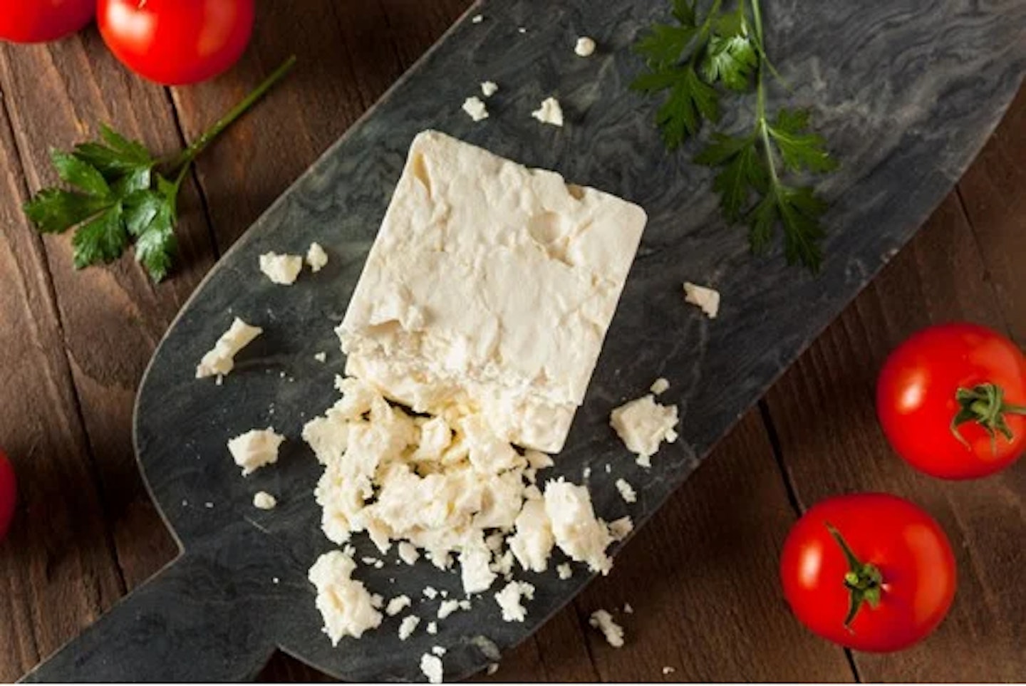 Feta cheese on a cheese board with tomatoes