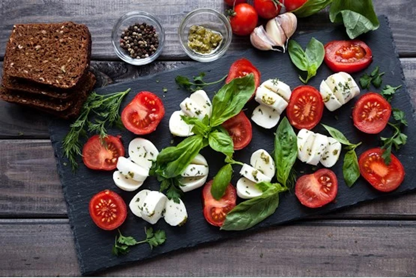 Mozzarella, tomato and basil on a slate board