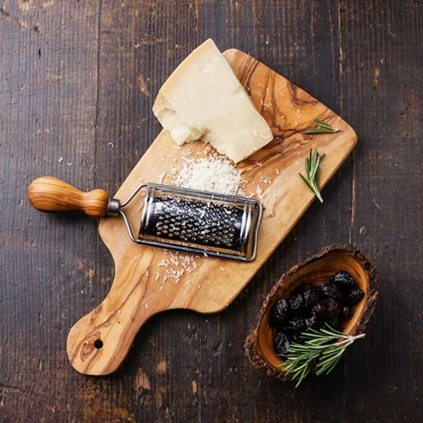Parmesan on a wooden board with a grater