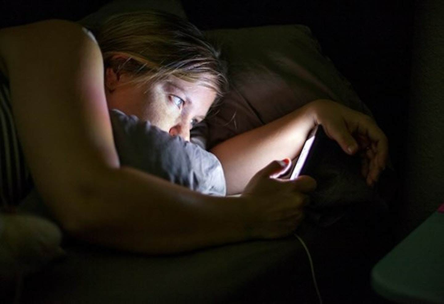 motherandbaby woman looking at phone in the dark