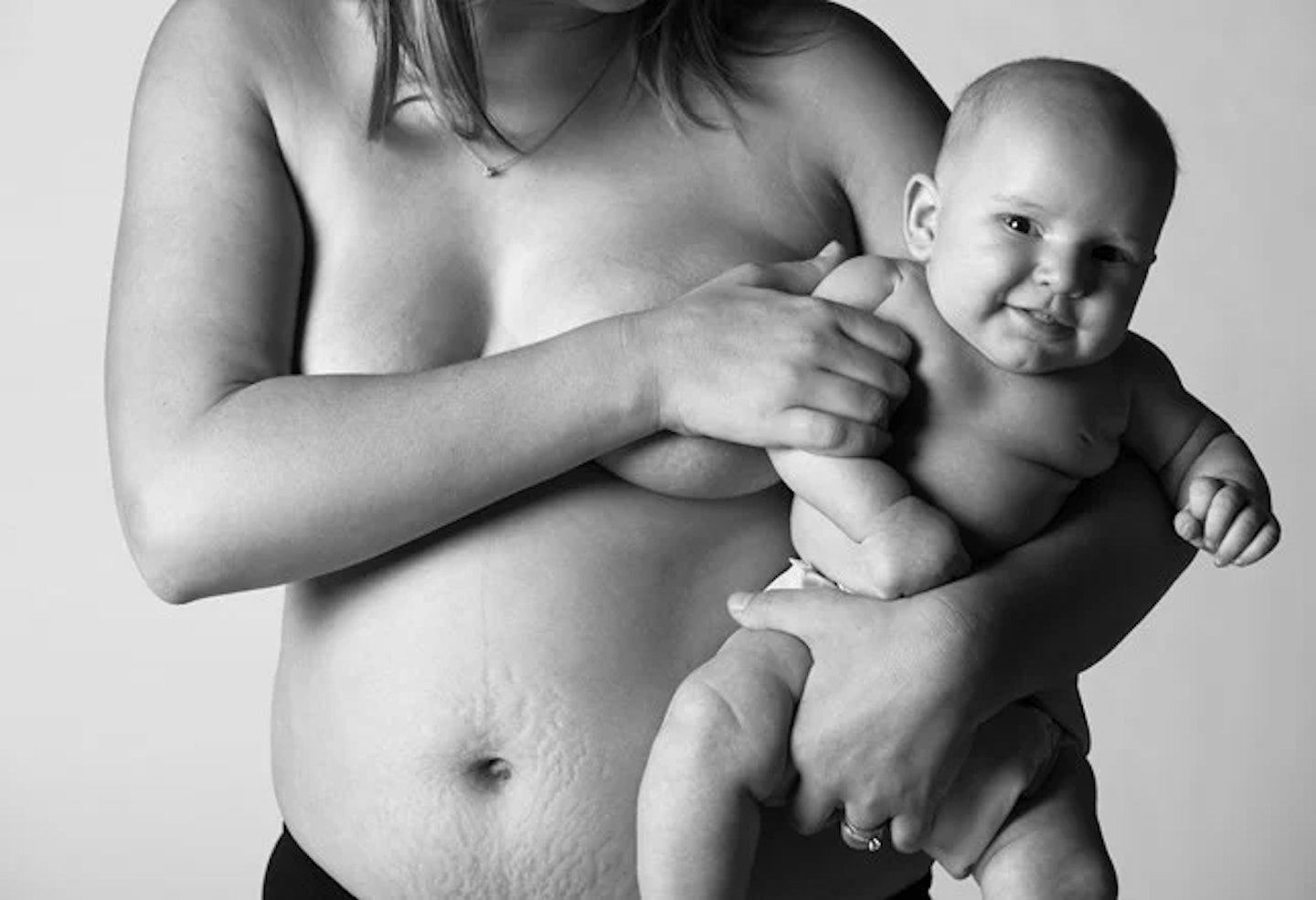 topless mother holding nude baby