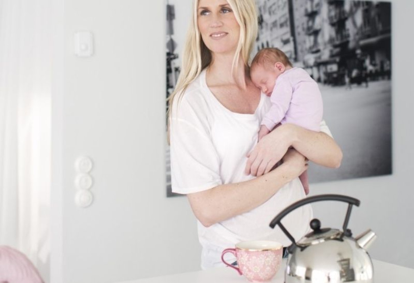 Mum carrying baby with kettle and cup