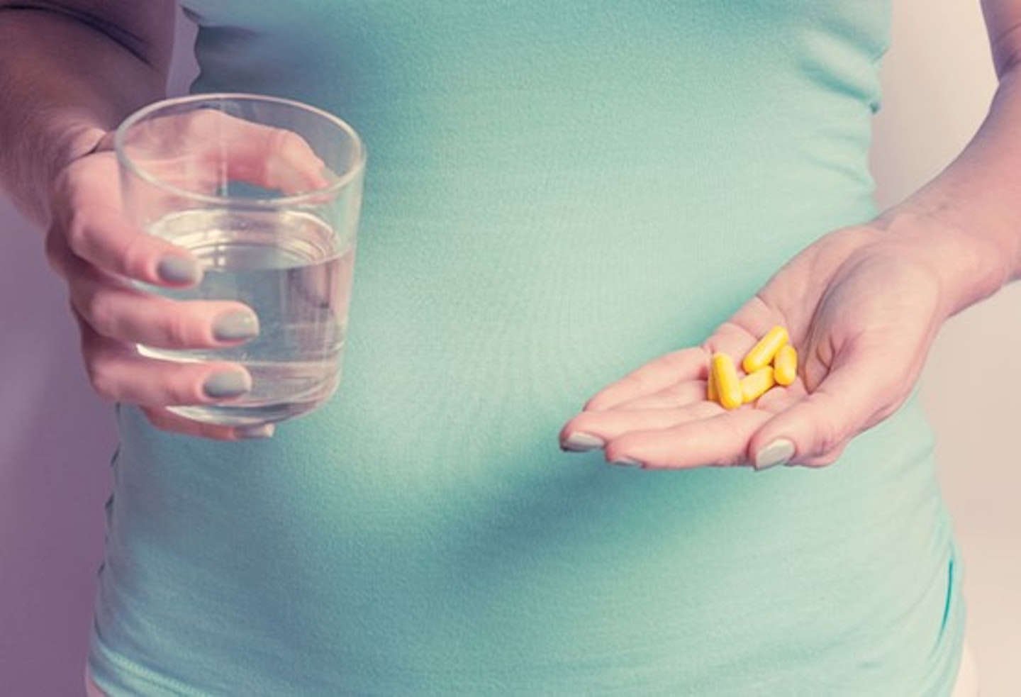 A woman holding vitamin capsules