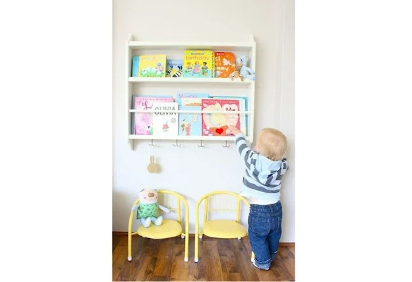 Toddler reaching for books on shelves