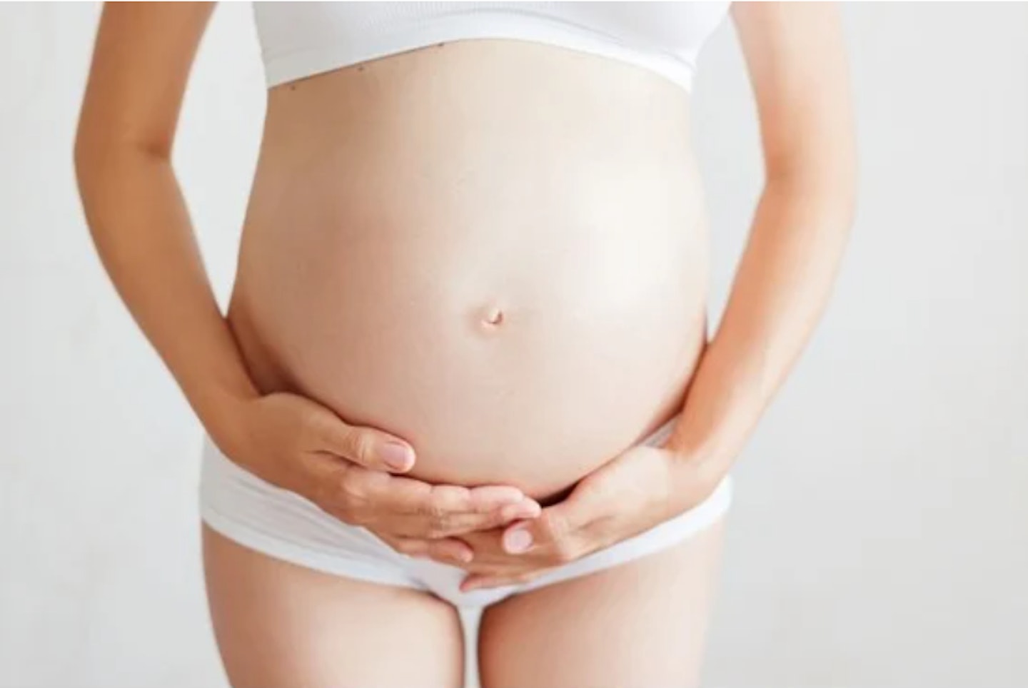 A woman holding her pregnant stomach