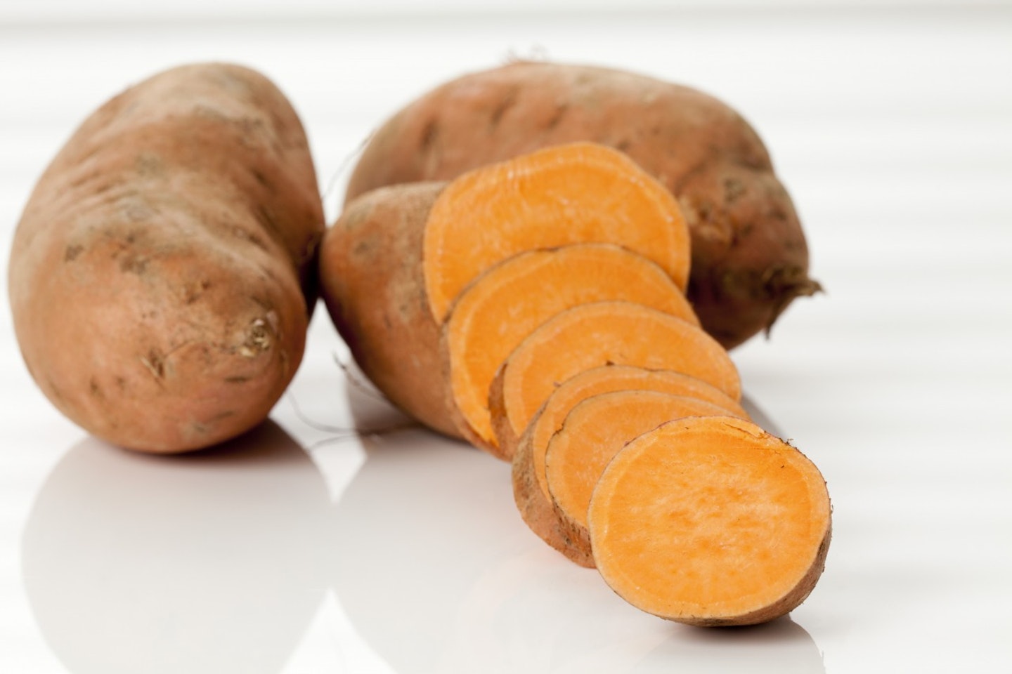 Sliced and whole sweet potatoes, close up