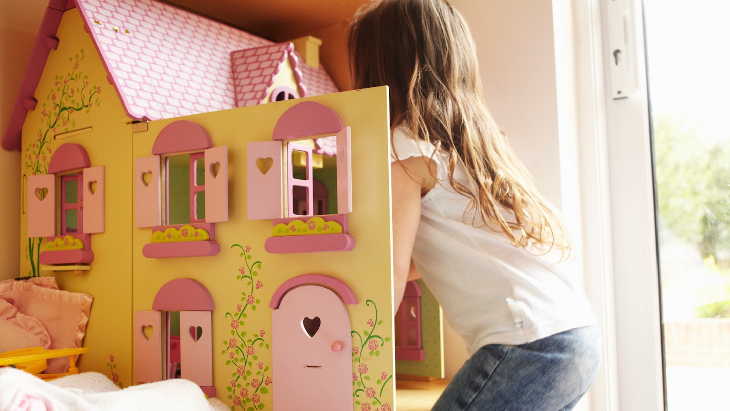 child looking inside a dollhouse