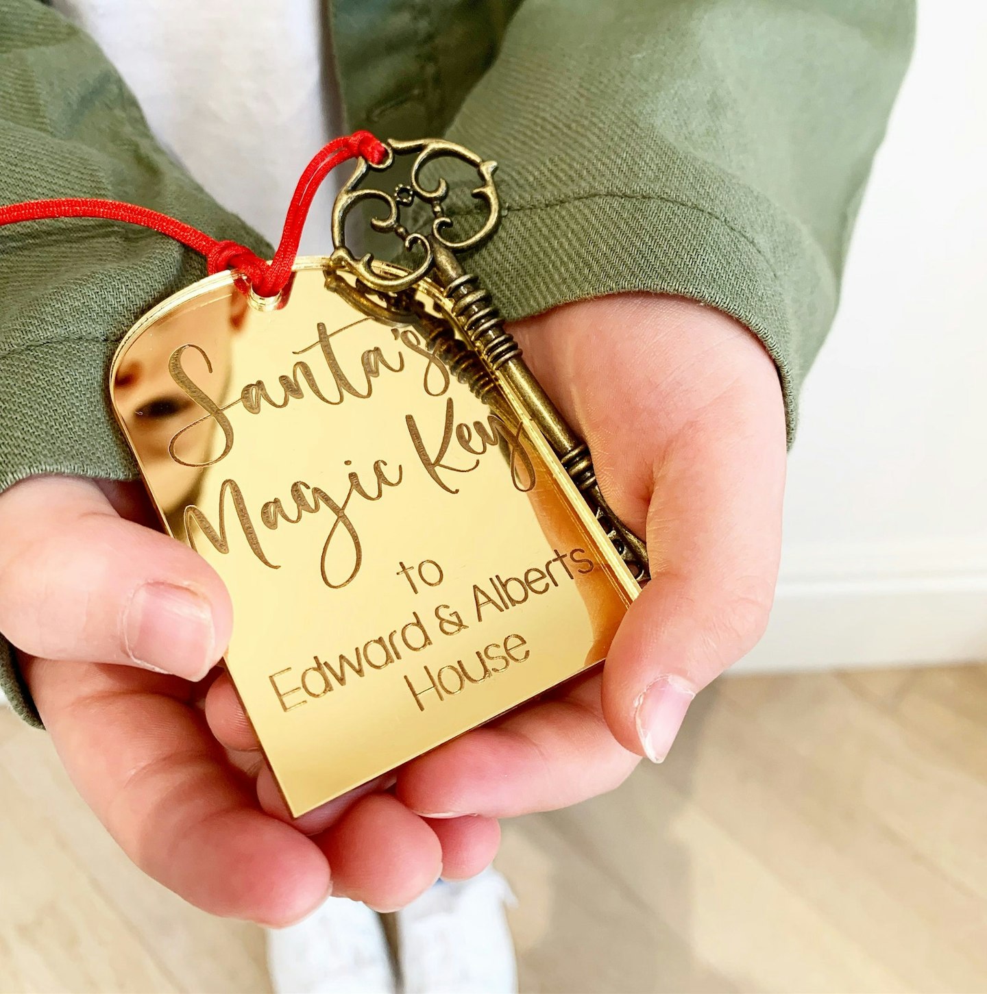 Hands holding a personalised-Santas-magic-key with mirrored gold label