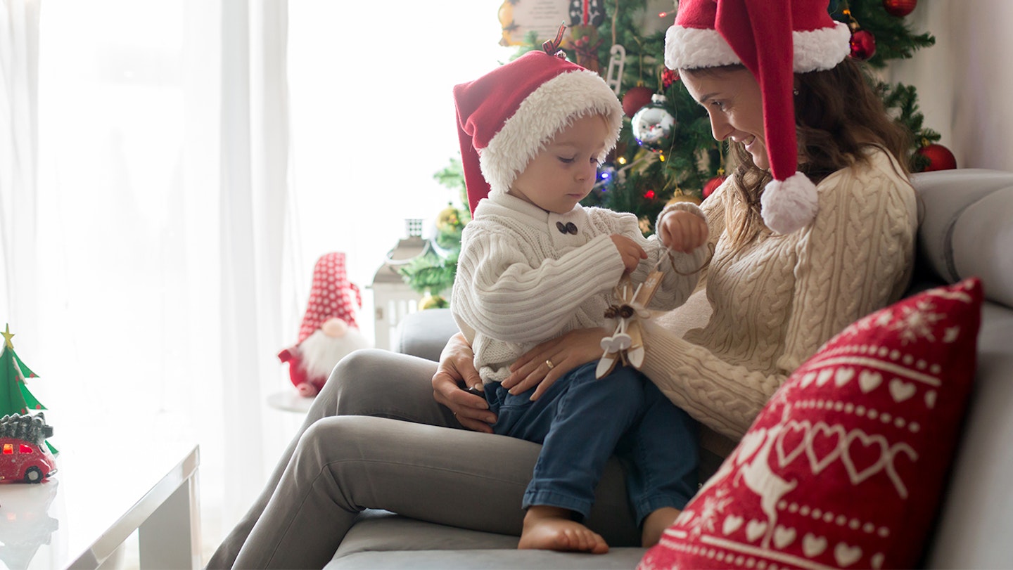 mum talking to son beside Christmas tree